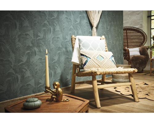 Dekoratives Zimmer mit Dschungeltapete, Holzstuhl, Kissen und Kerze.