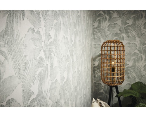 Raum mit tropischer Blättertapete und Rattan-Stehlampe