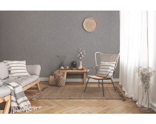 Salon lumineux avec canapé, chaise, tapis et papier peint gris