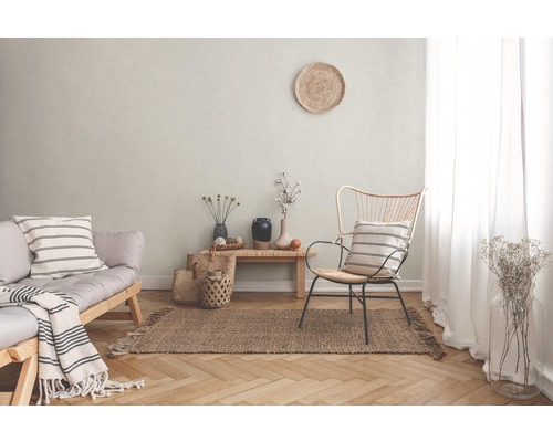 Wohnzimmer mit Sofa, Stuhl, Teppich und dekorativen Elementen für ein gemütliches Ambiente