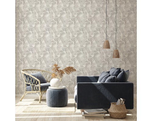 Salon lumineux avec papier peint à motif de feuilles de palmier, canapé et fauteuil