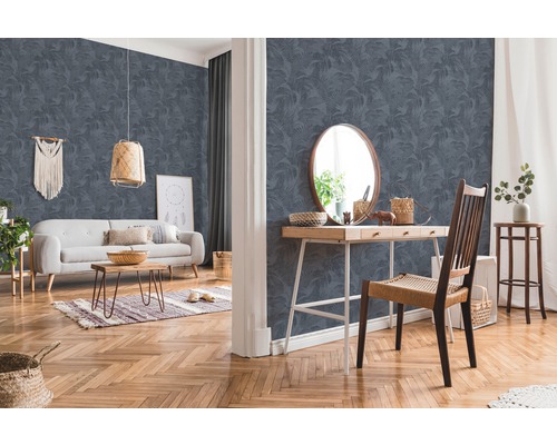 Salon avec papier peint à motifs, canapé, table et chaise.