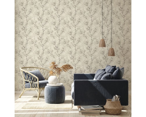 Salon avec papier peint à motifs, canapé, fauteuil et éléments décoratifs pour une ambiance chaleureuse