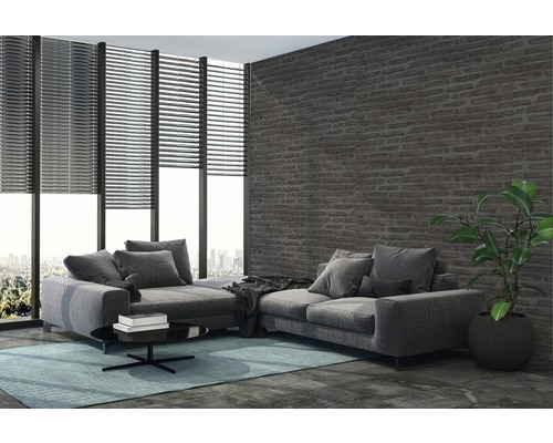 Salon avec canapé d''angle, stores et mur en briques