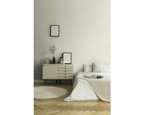 Schlafzimmer mit Bett, Kommode, rundem Teppich und Dekoration