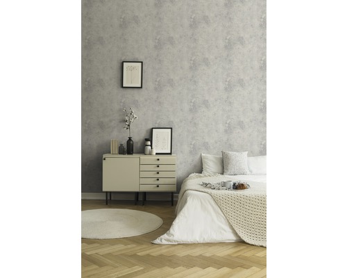 Chambre avec lit, commode et papier peint à motifs