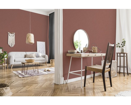 Salon avec papier peint à motifs, canapé, table et décorations pour une ambiance chaleureuse.