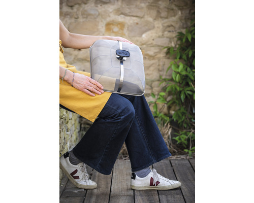 Frau hält tragbare Grillabdeckung mit ENO Logo.