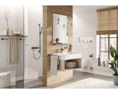 Salle de bains lumineuse avec douche, lavabo, miroir et fenêtre