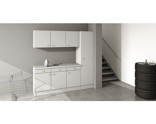 Scène avec meubles de garage blancs, fer à repasser, étendoir à linge et pile de pneus.