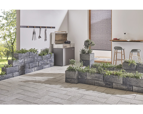 Terrasse avec barbecue, pierres à fleurs, herbes aromatiques et pavés