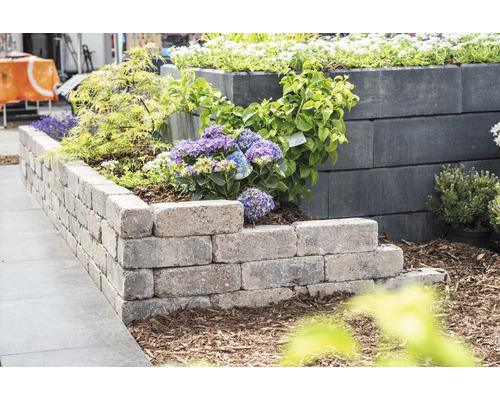 Gestufte Gartenmauer mit Pflanzen für einen strukturierten Aussenbereich.