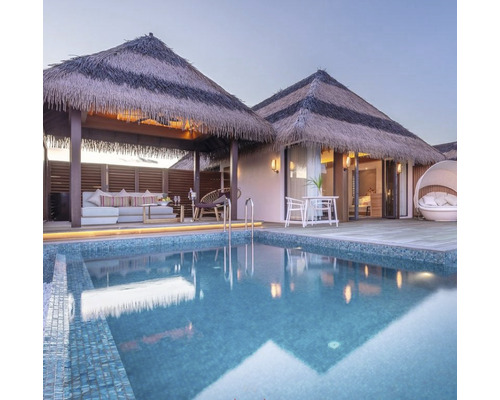 Poolbereich mit strohgedeckten Hütten und Sitzgelegenheiten im Freien