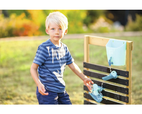 Enfant jouant avec un circuit d''eau en bois dans le jardin