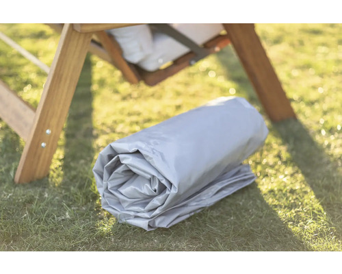 Housse de protection enroulée à côté d''une chaise en bois à l''extérieur sur l''herbe