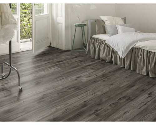 Chambre à coucher avec sol stratifié imitation bois, lit et porte de balcon