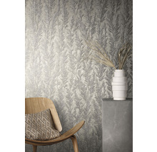 Vue d''une pièce avec du papier peint structuré à motif végétal, un fauteuil en bois et un vase blanc.