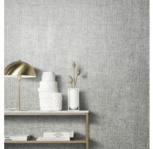 Gros plan d''un mur avec du papier peint textile et une table avec des décorations