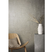 Gros plan d''un mur avec du papier peint textile, une chaise en bois et une décoration dans un vase