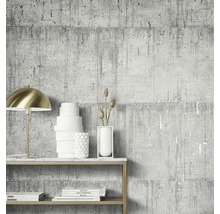 Scène avec un papier peint gris aspect béton, une lampe dorée et des objets décoratifs sur une étagère