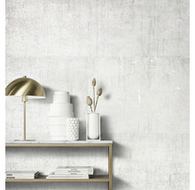 Pièce décorative avec lampe, vases et livres sur une table devant un mur texturé