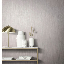 Gros plan d''un revêtement mural à texture verticale sur un mur dans une pièce avec des éléments décoratifs tels qu''une lampe et des vases.