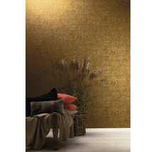 Dekoratives Interieur mit einer goldenen Tapete, Kissen und einem Ziergras in einem geflochtenen Korb.