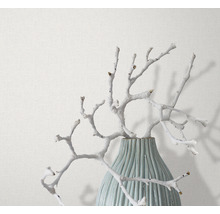 Dekorative Äste in einer Vase vor einer Tapete