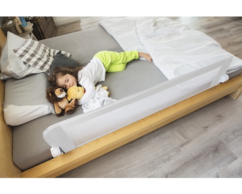 Kind schläft im Bett mit Bettgitter