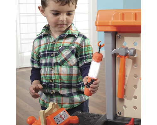 Kind spielt mit einer Werkbank und Werkzeugen