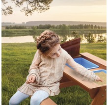 Fille jouant à une table de sable et d''eau dans le jardin.