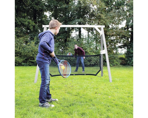 Deux personnes jouent au tennis avec un filet de tennis dans le jardin.