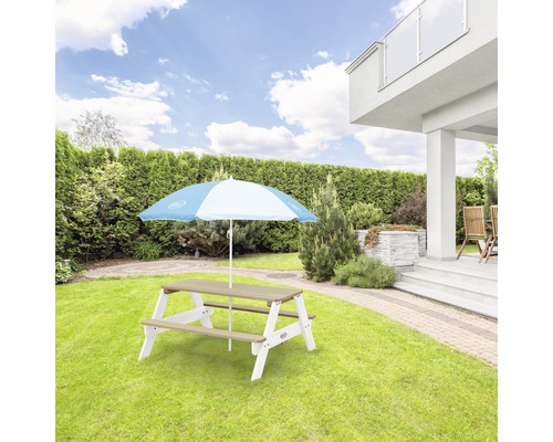 Table de pique-nique avec parasol dans le jardin
