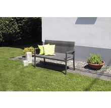 Banc de jardin en polyrotin avec coussins sur une pelouse