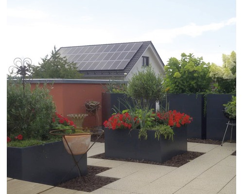 Terrasse mit bepflanzten Blumenkästen, Gartenhaus und Photovoltaikanlage auf dem Dach