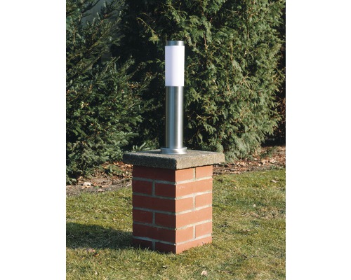 Gartenleuchte aus Edelstahl auf einem Sockel aus Ziegelsteinen