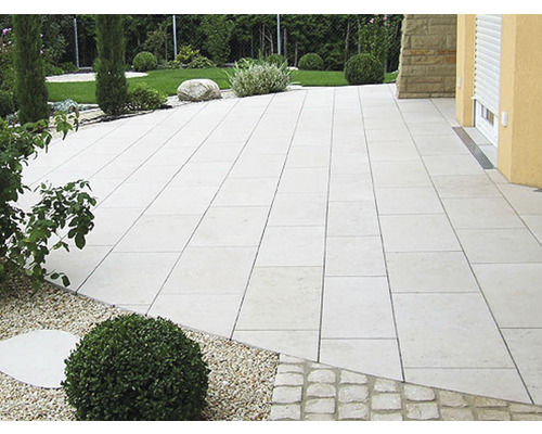 Terrasse mit Natursteinplatten, Garten und Hausfassade