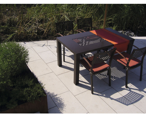 Quadratischer Gartentisch mit Stühlen auf einer Terrasse