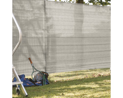 Filet de confidentialité sur clôture de jardin avec sac de sport, raquette de tennis et gourde