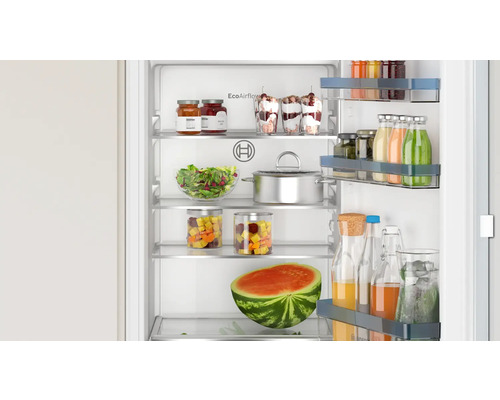 Réfrigérateur ouvert rempli d''aliments tels que pastèque, salades, desserts et boissons