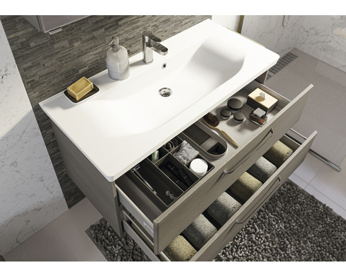 Badezimmer mit Waschbeckenunterschrank, Waschtisch, Armatur und geöffneten Schubladen