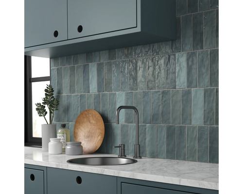 Küchenszene mit Spüle, Armatur und Wandfliesen in einem hellen, organisierten Stil.