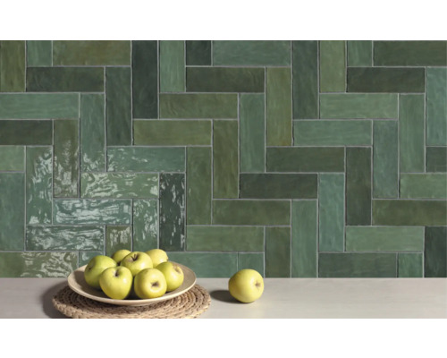 Wandfliesen mit Fischgrätenmuster und Äpfel auf einem Tisch