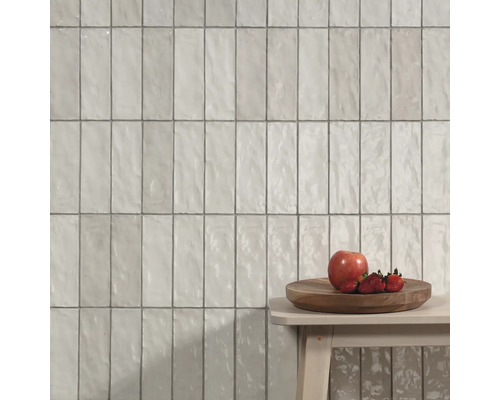 Wandfliesen im Hochformat mit Dekor auf einem Hocker mit Obst