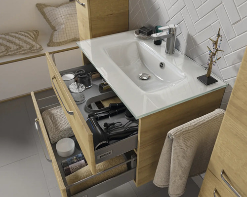 Meuble sous-lavabo avec tiroirs, lavabo et robinet dans la salle de bains.