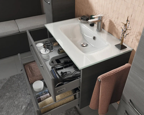 Salle de bain avec lavabo, tiroirs ouverts et accessoires de bain