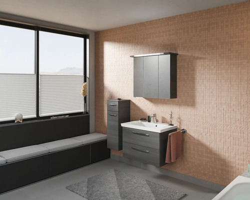 Salle de bains avec lavabo, armoire de toilette, armoire latérale et banquette sous la fenêtre