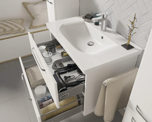 Meuble sous-lavabo de salle de bains avec tiroirs et divers accessoires de salle de bains.