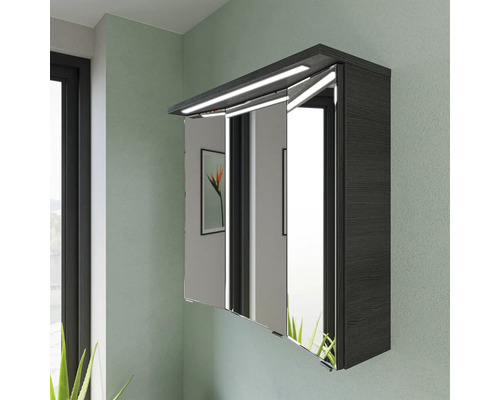 Armoire de toilette à trois portes avec éclairage fixé au mur.