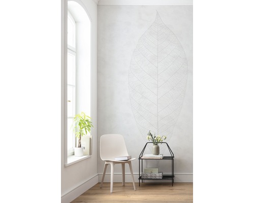 Pièce lumineuse avec chaise, table d''appoint, plante et sticker mural en forme de feuille
